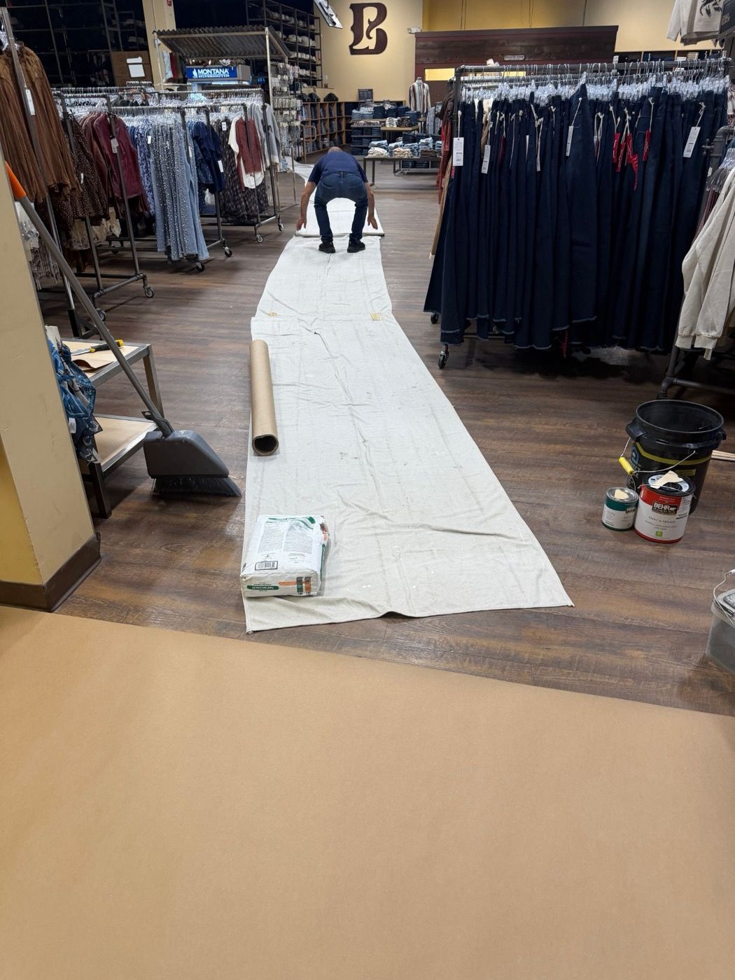 Retail sales floor protected with drop cloths and paper between the displays during a commercial job